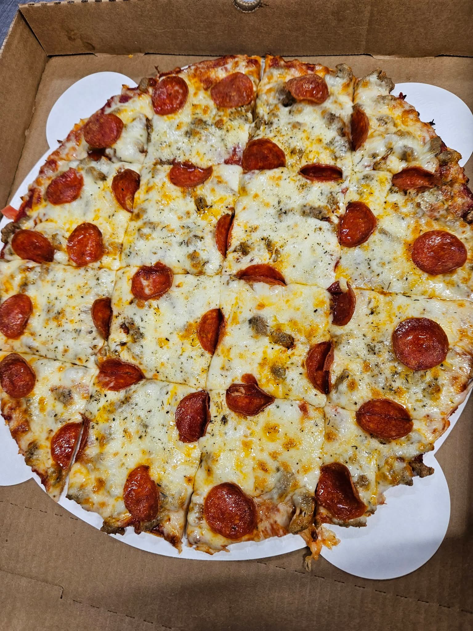 Pepperoni and sausage pizza cut into squares
